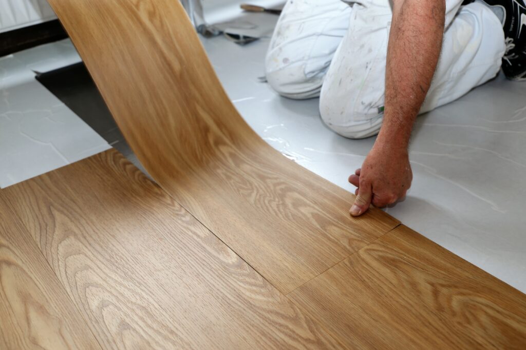 Someone from Bevel Interiors laying down Vinyl flooring
